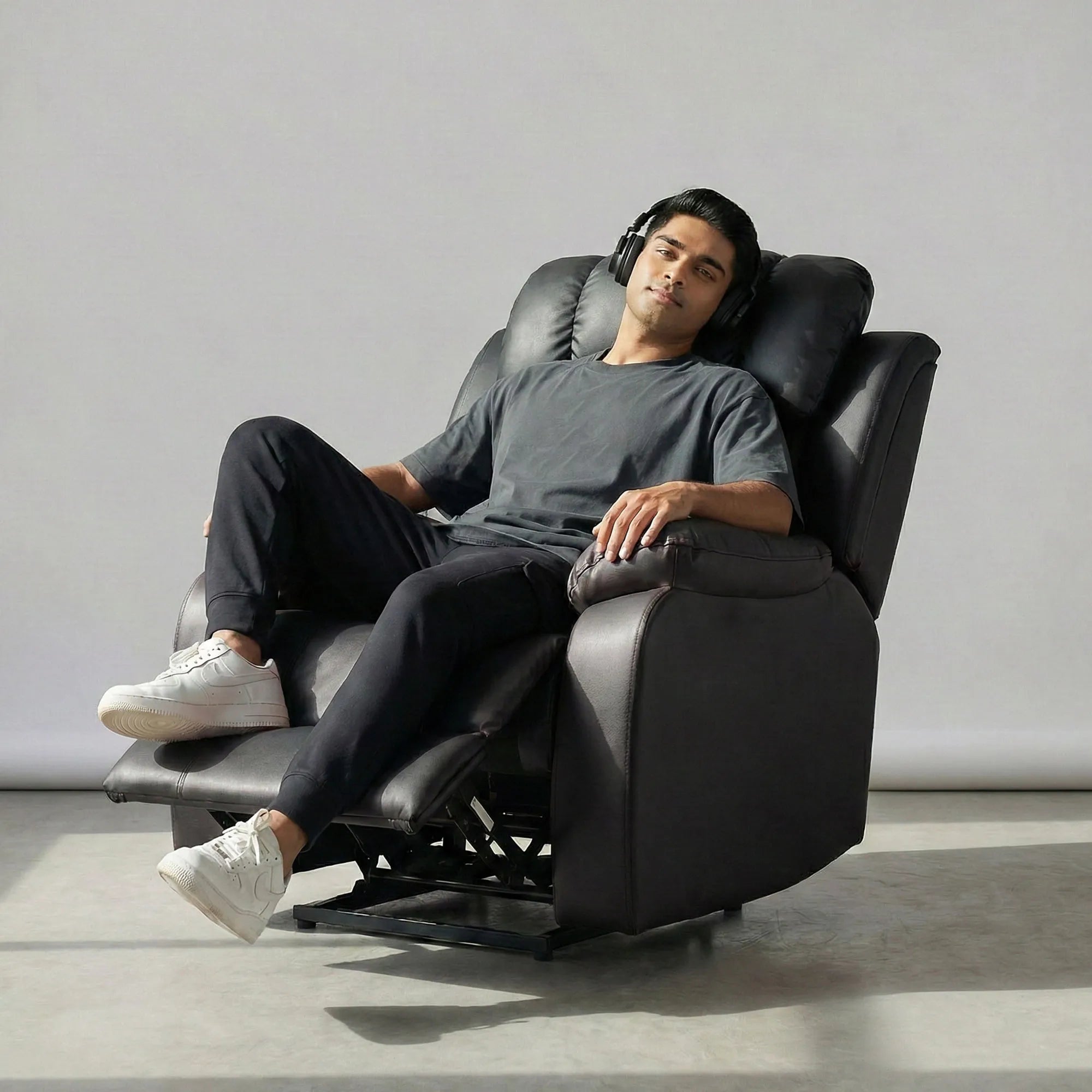 Man relaxing on Hush Hiven Big B black motorized recliner leatherette single seater power recliner