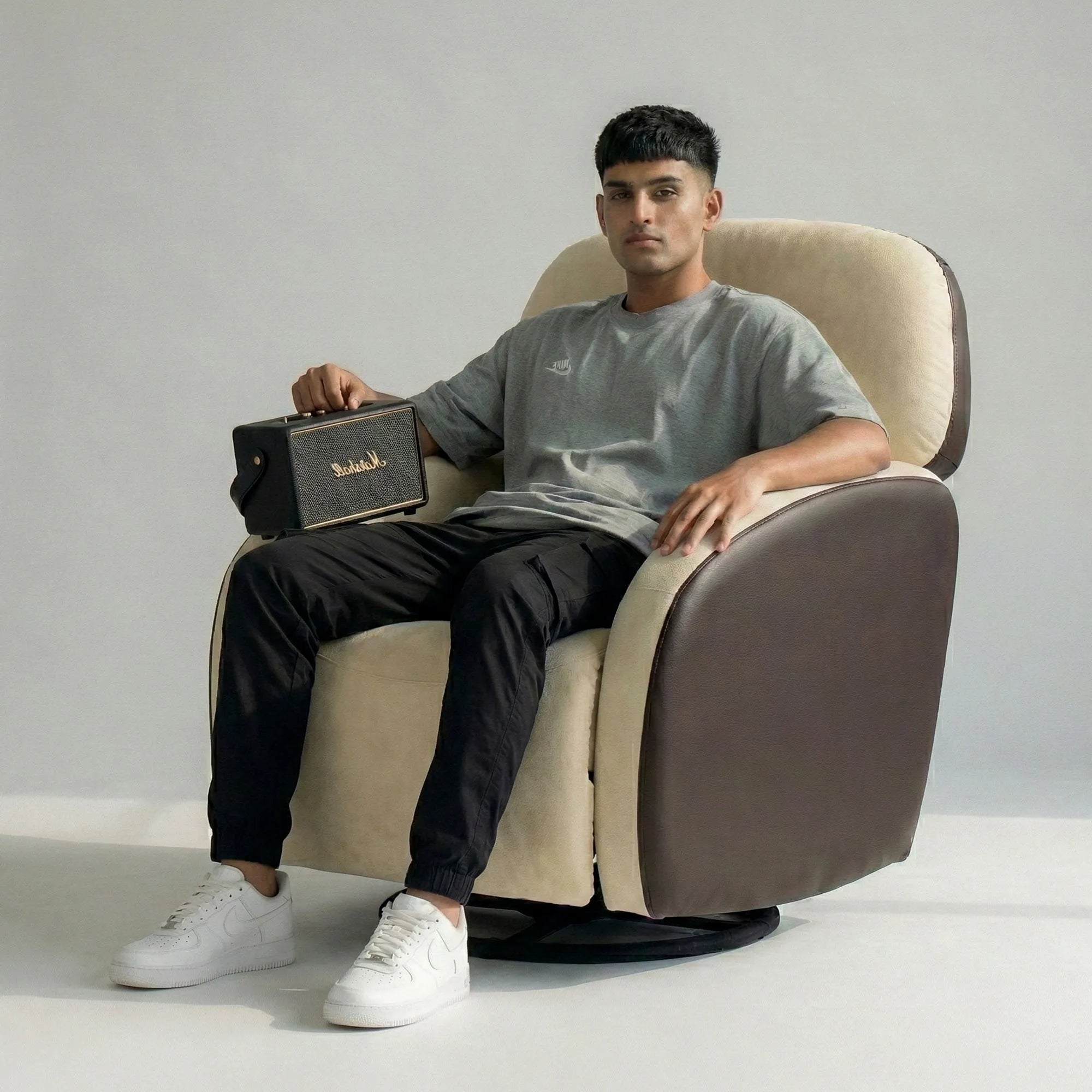 Man sitting on Hush Hiven Pebble motorized recliner chair brown dual tone boucle leatherette single seater