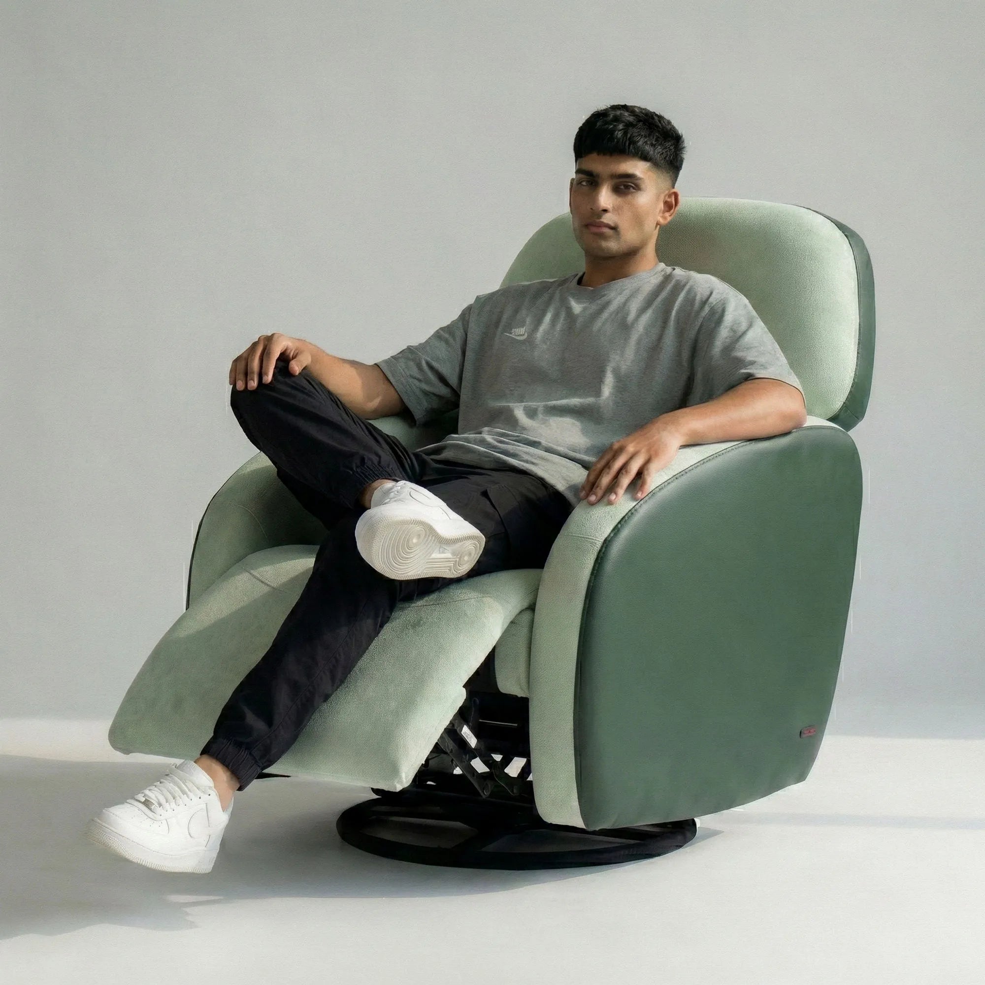 Man relaxing on Hush Hiven Pebble motorized recliner chair green dual tone boucle leatherette recliner