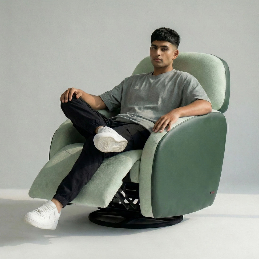 Man relaxing on Hush Hiven Pebble motorized recliner chair green dual tone boucle leatherette recliner