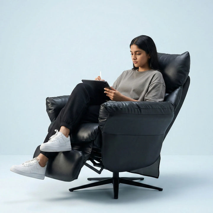 Person sitting in a Hush Hiven Shadow black motorised recliner chair Office Gaming Leatherette recliner reading a book against a light blue background