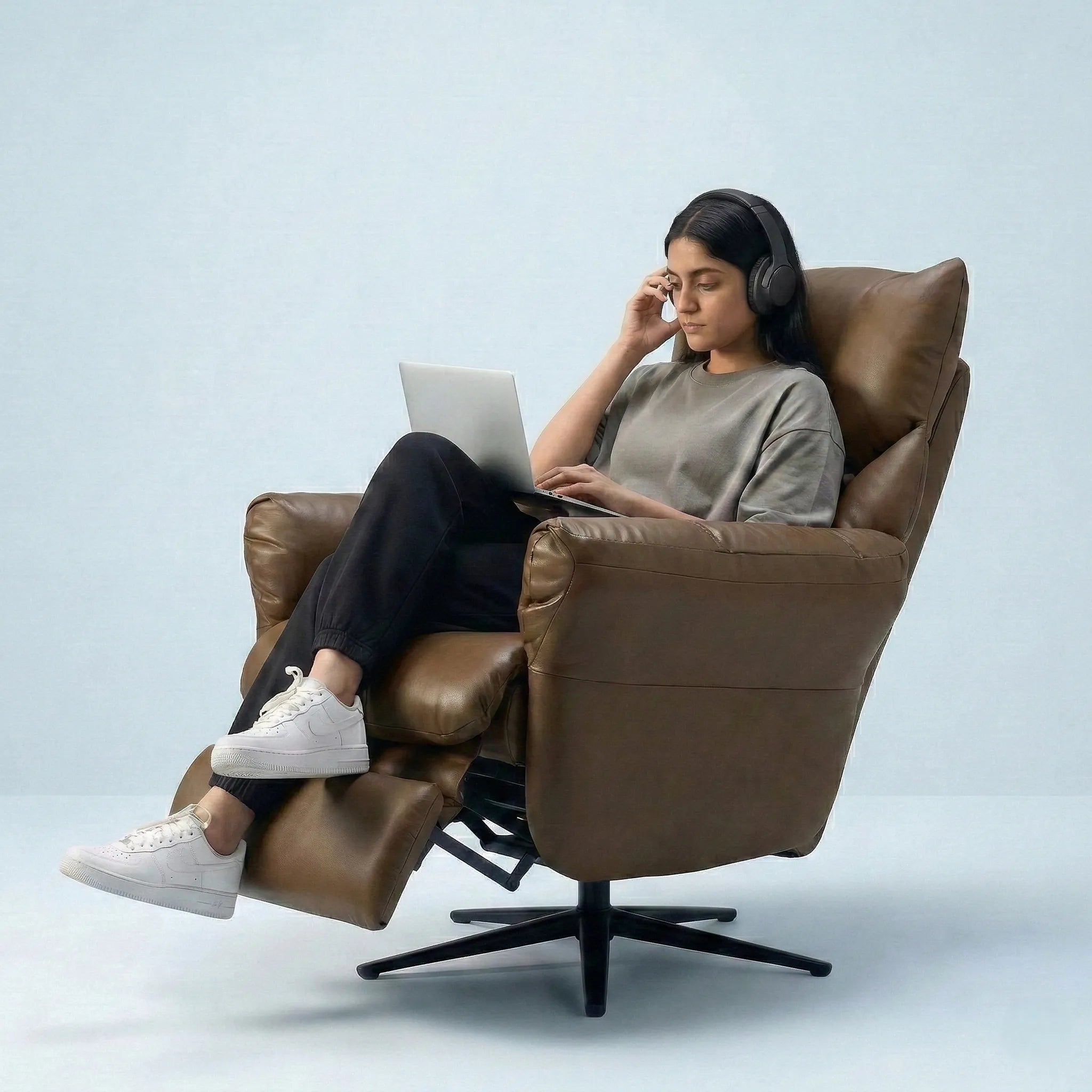 Woman using tablet while sitting on Hush Hiven Shadow brown motorized leatherette recliner chair