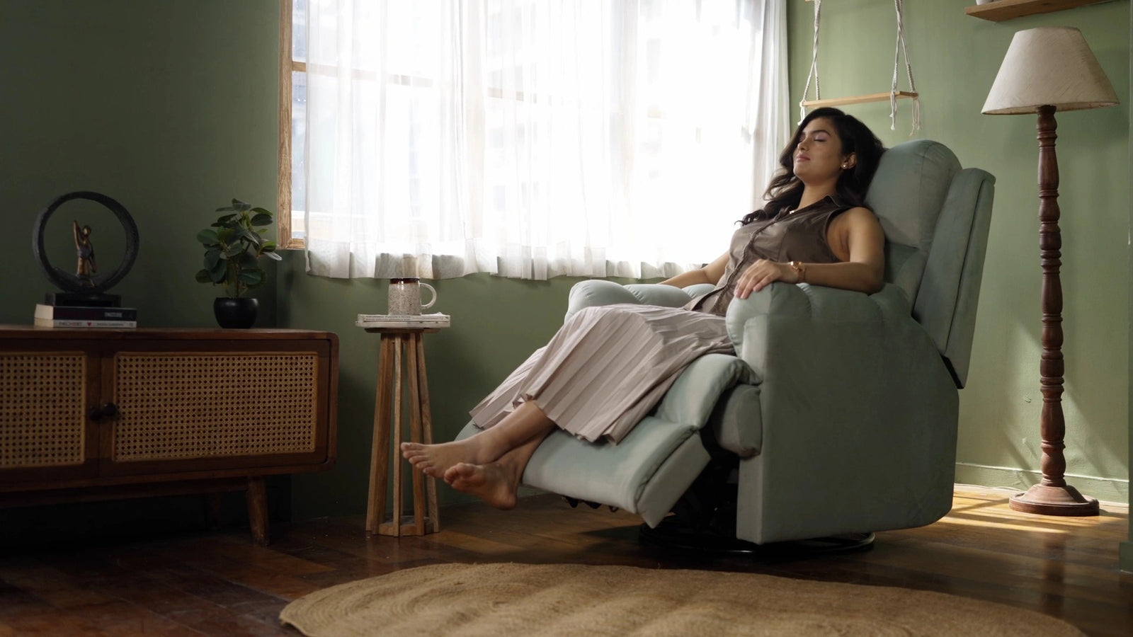 Woman relaxing in a Donna recliner chair in a cozy living room.